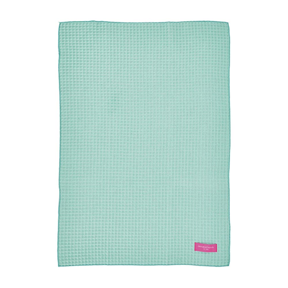 Mint green textured hand towel with a brand logo on a white background